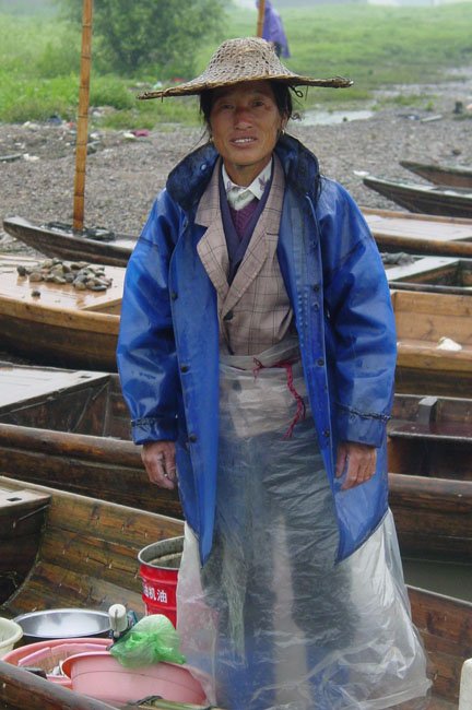shutterstock_232989 Zhejiang, a woman fisher standing on her boat in a rainy day in Zhejiang China