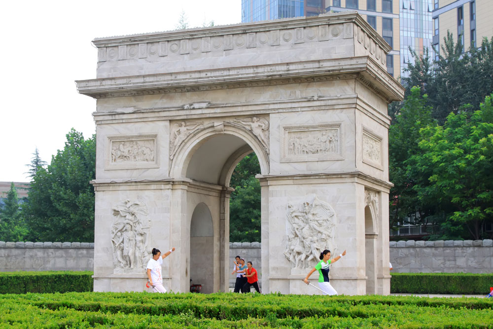 shutterstock_137515010 Hebei, A lady in practicing Swordsmanship in front of the Triumphal Arch in the Stone Door park